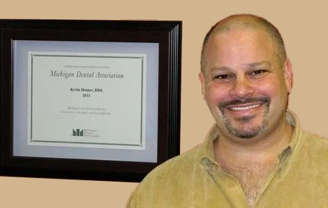 Dr. Kevin M. Homer, D.D.S., beside his Michigan Dental Association certificate at Edward Street Dental