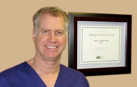 Dr. Jeffrey E. Watzman, D.D.S., beside his Michigan Dental Association certificate at Edward Street Dental